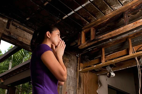 a woman looking at damage that restoration services las vegas is going to repair